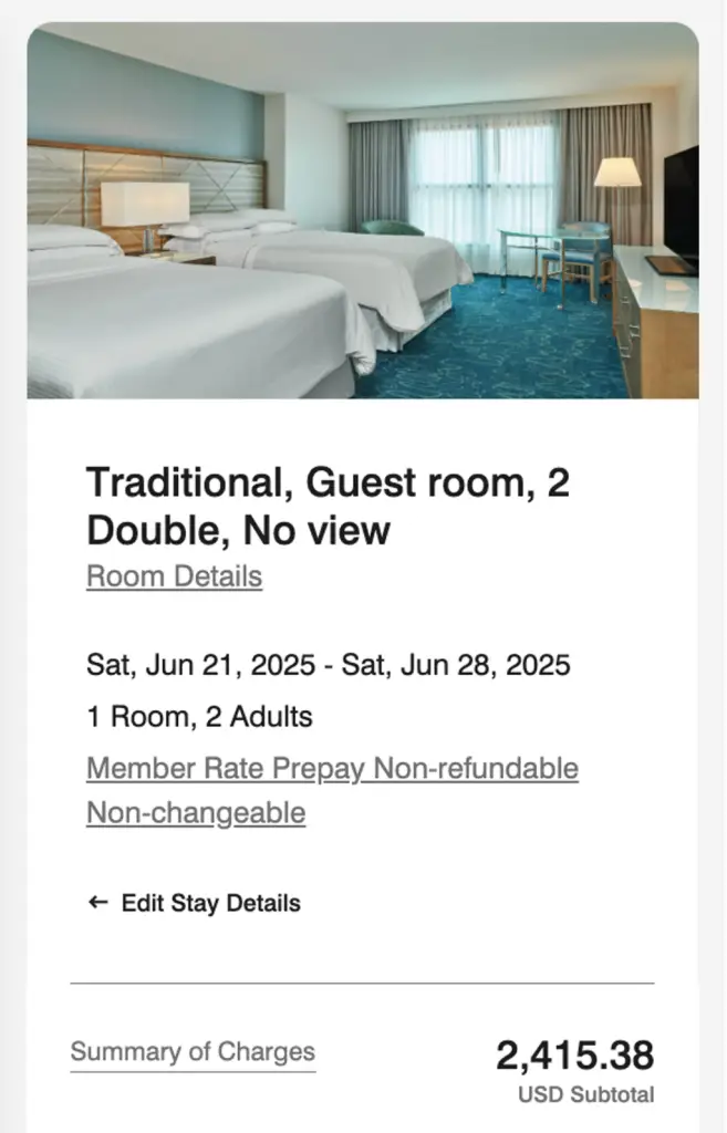 A hotel guest room with two double beds, featuring a modern design and soft lighting, with a view of sheer curtains and a television in the background. Room details state it's a traditional room with no view, available from June 21 to June 28, 2025 for two adults.