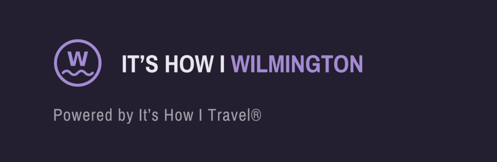White W in a circle above a wavy line, next to ITS HOW I WILMINGTON with WILMINGTON in bold purple, highlighting the vibrant spirit of Wilmington. Below, gray text reads, Powered by Its How I Travel®, all on a dark background.
